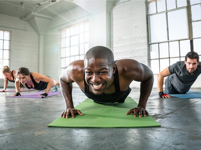 two people working out with a weight in each hand